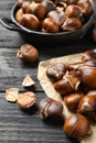 Tasty roasted edible chestnuts on black wooden table, closeup Royalty Free Stock Photo