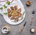 Tasty roasted pieces of pork with mushroom sauce on a white plate with herbs and vintage cutlery wooden rustic background top v Royalty Free Stock Photo