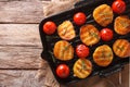 Tasty roasted potatoes and tomatoes with rosemary close up on a