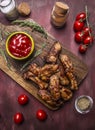 Tasty roasted ribs with spicy sauce and herbs on a cutting board on wooden rustic background top view close