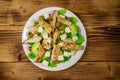 Tasty salad with fried chicken breast, green olives, feta cheese, avocado, lettuce and olive oil on wooden table. Top view Royalty Free Stock Photo