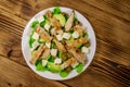 Tasty salad with fried chicken breast, green olives, feta cheese, avocado, lettuce and olive oil on wooden table. Top view Royalty Free Stock Photo