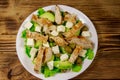 Tasty salad with fried chicken breast, green olives, feta cheese, avocado, lettuce and olive oil on wooden table. Top view Royalty Free Stock Photo