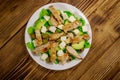 Tasty salad with fried chicken breast, green olives, feta cheese, avocado, lettuce and olive oil on wooden table. Top view Royalty Free Stock Photo