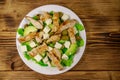 Tasty salad with fried chicken breast, green olives, feta cheese, avocado, lettuce and olive oil on wooden table. Top view Royalty Free Stock Photo