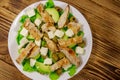 Tasty salad with fried chicken breast, green olives, feta cheese, avocado, lettuce and olive oil on wooden table. Top view Royalty Free Stock Photo