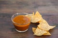 Tasty salsa sauce and Mexican nacho chips on wooden table, closeup Royalty Free Stock Photo