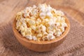 Tasty salty popcorn in wooden bowl on burlap napkin Royalty Free Stock Photo