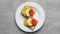 Tasty sandwiches with boiled egg, avocado and tomato on grey table, top view Royalty Free Stock Photo