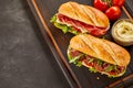 Tasty sandwiches on dark wooden tray Royalty Free Stock Photo