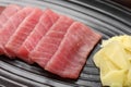 Tasty sashimi (pieces of fresh raw tuna) and ginger slices on plate, closeup