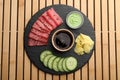 Tasty sashimi (pieces of fresh raw tuna), sliced cucumber, soy sauce, wasabi and ginger slices on wooden table, top view Royalty Free Stock Photo