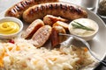 Tasty sauerkraut with grilled sausages and sauces on plate, closeup Royalty Free Stock Photo
