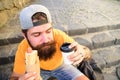 Tasty sausage in roasty bun. Urban food culture concept. Hipster eat hot dog while sit on stairs outdoors. Hipster enjoy Royalty Free Stock Photo