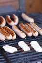 Tasty sausages sizzling on a portable BBQ fire grilling over the flames on a summer picnic, close up view.preparing bbq Royalty Free Stock Photo