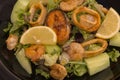 Tasty seafood. mixed salad shrimps, fish and squids with lemon and vegetables. Royalty Free Stock Photo
