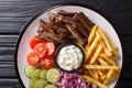 Tasty shawarma bowl with lamb, french fries, vegetables and sauce close-up. horizontal top view