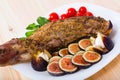 Tasty shoulder of lamb baked in oven with honey, served with fig, feta cheese and herbs