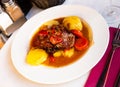 Tasty shoulder of lamb baked in oven with potatoes and stewed vegetables