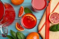 Tasty sicilian orange juice and fruits on light blue wooden table, flat lay Royalty Free Stock Photo