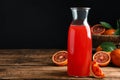 Tasty sicilian orange juice in glass bottle and fruits on wooden table, space for text Royalty Free Stock Photo