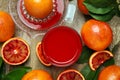 Tasty sicilian orange juice in glass, squeezer and fruits on wooden table, flat lay Royalty Free Stock Photo