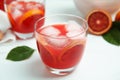 Tasty sicilian orange juice with ice cubes on white table, closeup