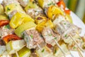 Tasty skewers of fresh fish with vegetables and apples on a wooden shish kebab Royalty Free Stock Photo