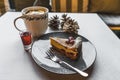 Tasty slice of cheesecake served with winter tea and shot of rum standing on a table at a cafe shop. Royalty Free Stock Photo