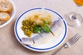 Tasty slices herring fish with canned green peas, pickled cabbage, decorated by onion rings served on plate Royalty Free Stock Photo