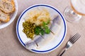 Tasty slices herring fish with canned green peas, pickled cabbage, decorated by onion rings served on plate Royalty Free Stock Photo