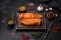 Tasty smoked fillet of chicken breast with spices and herbs on a wooden cutting board Royalty Free Stock Photo