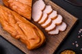 Tasty smoked fillet of chicken breast with spices and herbs on a wooden cutting board Royalty Free Stock Photo