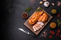 Tasty smoked fillet of chicken breast with spices and herbs on a wooden cutting board Royalty Free Stock Photo