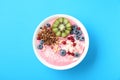 Tasty smoothie bowl with fresh kiwi fruit, berries and granola on light blue background, top view Royalty Free Stock Photo