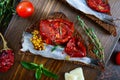 Tasty smorrebrod on a wooden board. Sandwiches with black rye bread, sun-dried tomatoes, salted anchovies, mustard Royalty Free Stock Photo