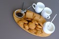 A tasty snack two cups of black tea and a plate of oatmeal cookies a wooden board on the gray background, leaf tea. Royalty Free Stock Photo