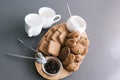 A tasty snack two cups of black tea and a plate of oatmeal cookies a wooden board on the gray background, leaf tea. Royalty Free Stock Photo