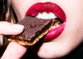 Tasty snack. Woman bites a waffle in chocolate. Female lips with red lipstick. Girl concept. Face close up.