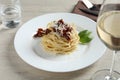 Tasty spaghetti with sun-dried tomatoes and parmesan cheese served on wooden table, closeup. Exquisite presentation of pasta dish Royalty Free Stock Photo