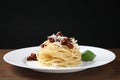 Tasty spaghetti with sun-dried tomatoes and parmesan cheese on wooden table, closeup. Exquisite presentation of pasta dish Royalty Free Stock Photo