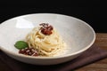 Tasty spaghetti with sun-dried tomatoes and cheese on wooden table, closeup. Exquisite presentation of pasta dish Royalty Free Stock Photo