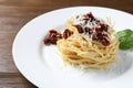 Tasty spaghetti with sun-dried tomatoes and parmesan cheese on wooden table, closeup. Exquisite presentation of pasta dish Royalty Free Stock Photo