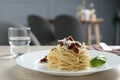 Tasty spaghetti with sun-dried tomatoes and parmesan cheese on wooden table in restaurant, closeup. Exquisite presentation of Royalty Free Stock Photo