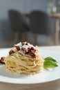 Tasty spaghetti with sun-dried tomatoes and parmesan cheese on table in restaurant, closeup. Exquisite presentation of Royalty Free Stock Photo