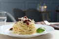 Tasty spaghetti with sun-dried tomatoes and parmesan cheese on table in restaurant, closeup. Exquisite presentation of Royalty Free Stock Photo