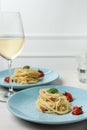 Tasty spaghetti with tomatoes and cheese served on white wooden table, closeup. Exquisite presentation of pasta dish Royalty Free Stock Photo