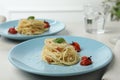 Tasty spaghetti with tomatoes and cheese served on wooden table, closeup. Exquisite presentation of pasta dish Royalty Free Stock Photo