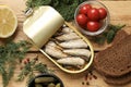 Tasty sprats in tin can served on wooden table, flat lay Royalty Free Stock Photo