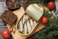 Tasty sprats in tin can served on wooden table, flat lay Royalty Free Stock Photo